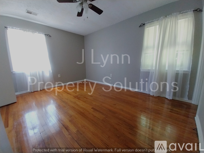 A room with wooden flooring and a ceiling fan.