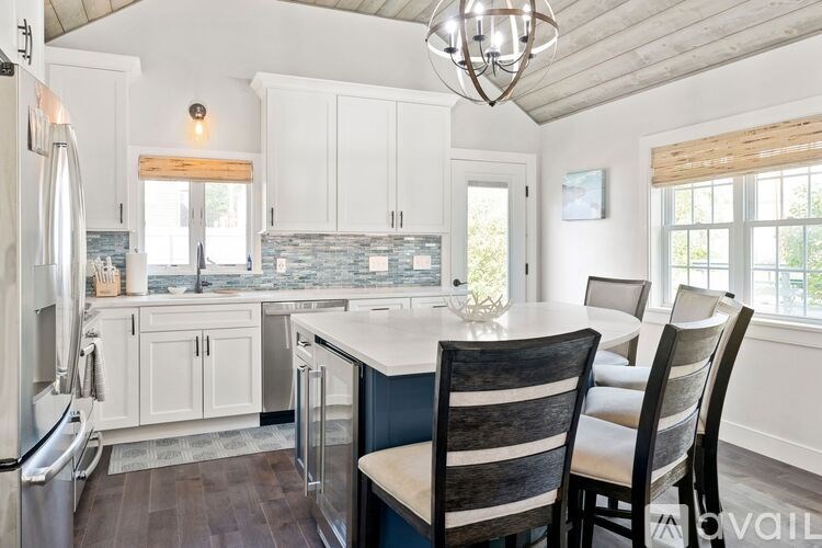 A kitchen with a table and chairs.