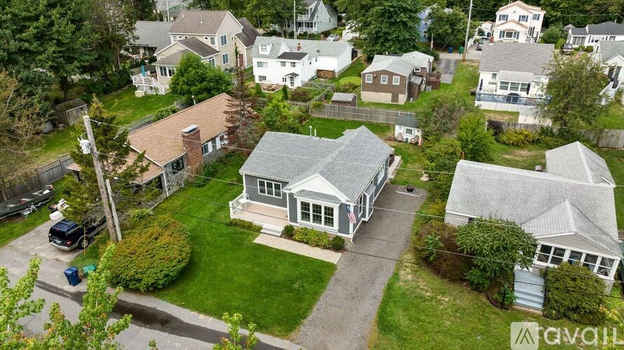 A house with a grey roof is surrounded by other houses.