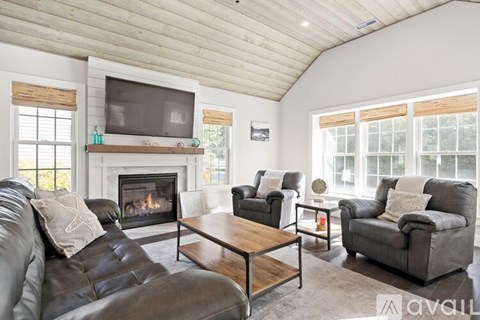 A living room with a fireplace and a television on the wall.