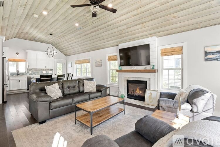 A living room with a grey couch, a wooden coffee table, and a fireplace.