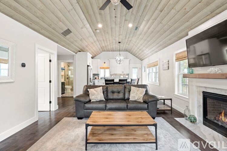 A modern living room with a black leather couch and a wooden coffee table.