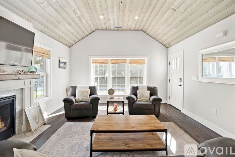 A living room with a fireplace and two grey couches.