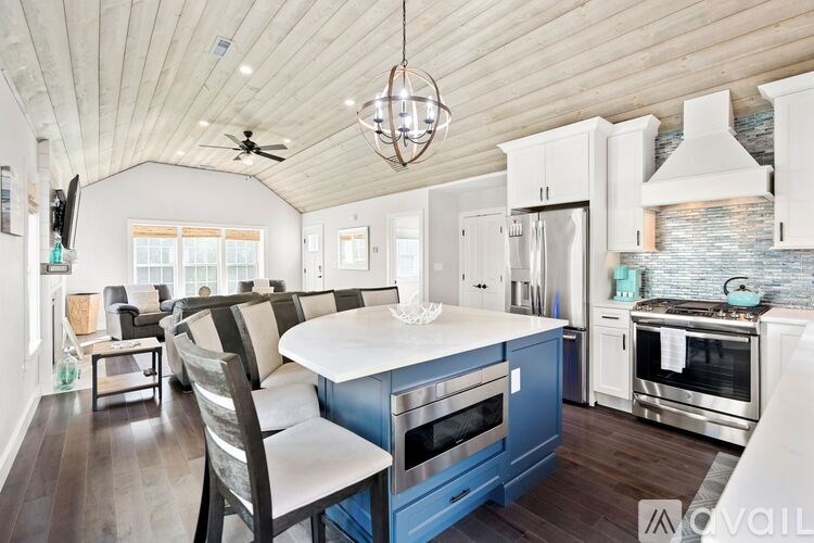A modern kitchen with a blue island and stainless steel appliances.