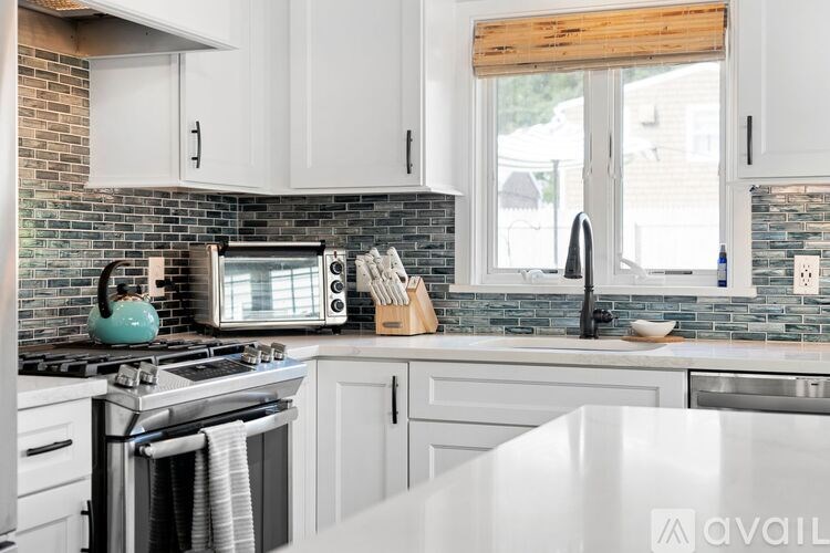 A kitchen with a white countertop and a window with wooden blinds.