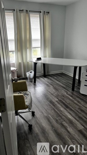 A living room with a grey couch, a grey ottoman, a grey coffee table, and a grey rug.