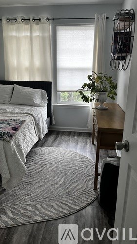 A bedroom with a round bed and a small table with a plant on it.