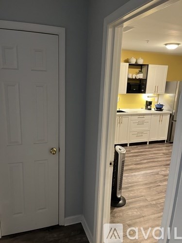 A bedroom with a bed, a window with a curtain, and a ceiling fan.