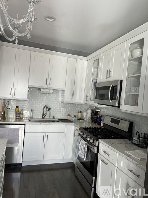 A kitchen with white cabinets and a black stove top.