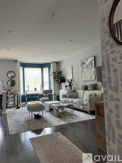 A living room with a couch, a chair, a coffee table, and a mirror on the wall.