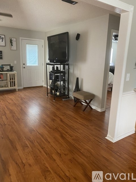 A living room with a television and a chair.