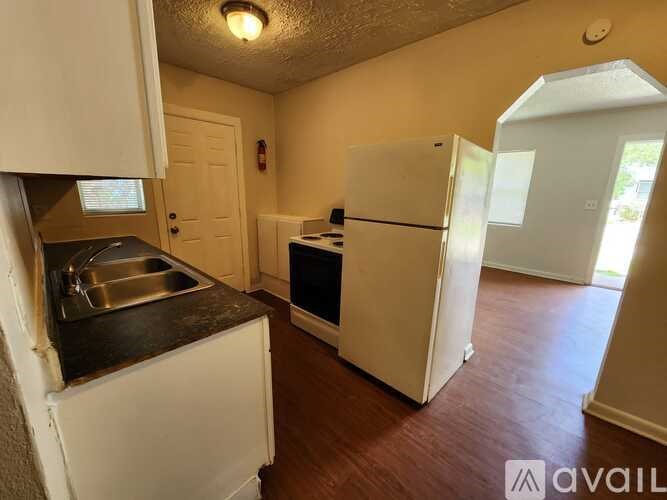 A kitchen with a sink, stove, and refrigerator.