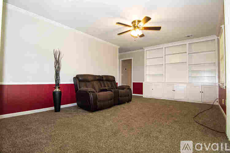 A room with a brown couch and a floor lamp.