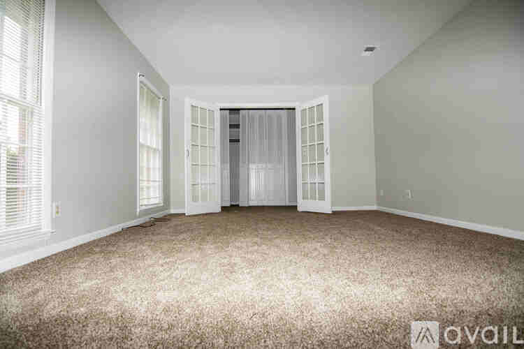 A room with a carpeted floor and a door with a glass panel.