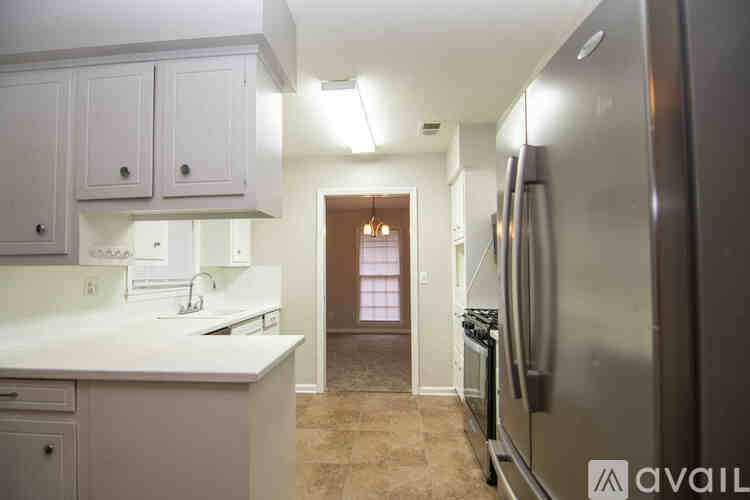 A kitchen with white cabinets and a refrigerator.