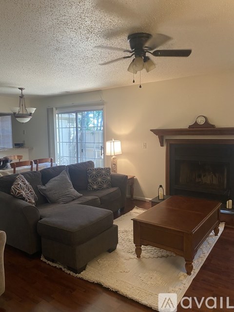 A living room with a grey couch and a wooden coffee table.