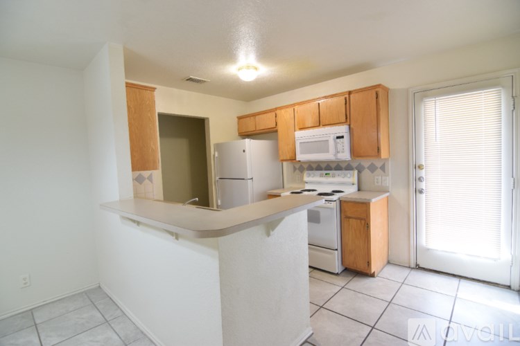 A kitchen with white appliances and wooden cabinets.