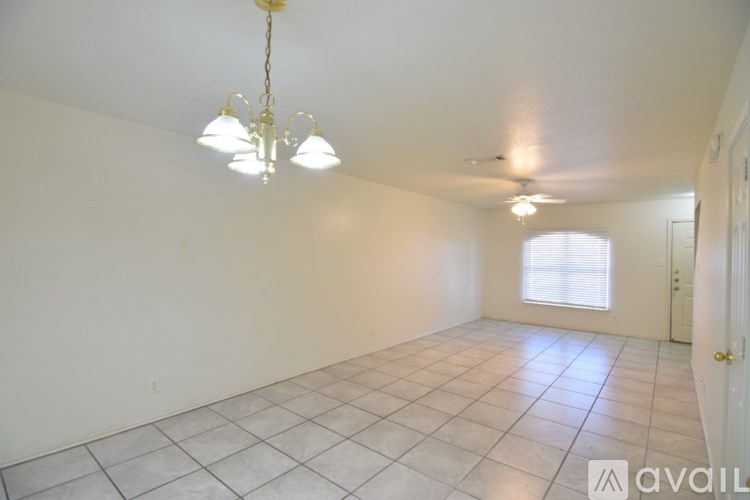 A room with a chandelier and a window with blinds.