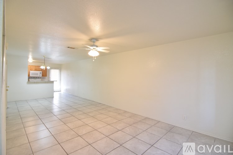 A room with a ceiling fan and tiled floor.