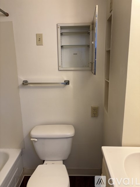 A white toilet in a small bathroom with a mirror above it.