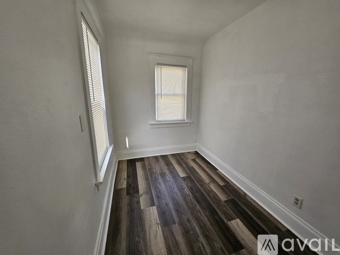 A room with wooden flooring and a window.