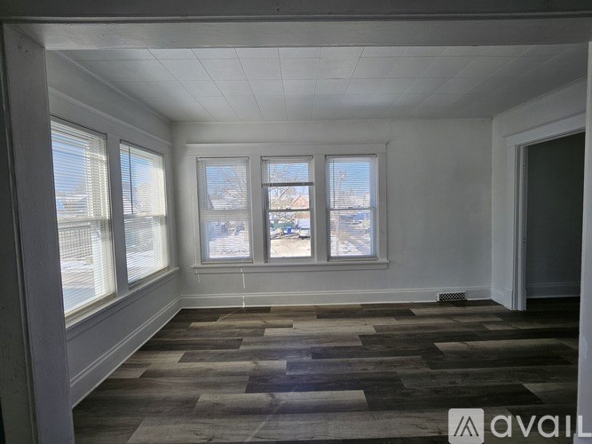 A room with a checkered floor and three windows.