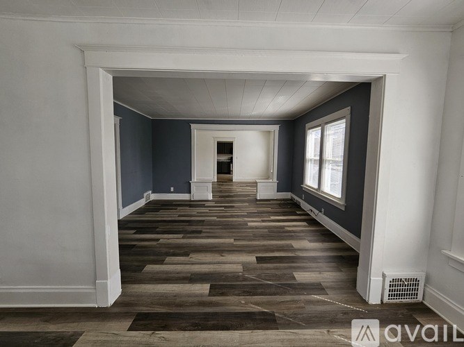 A room with wooden flooring and white walls.