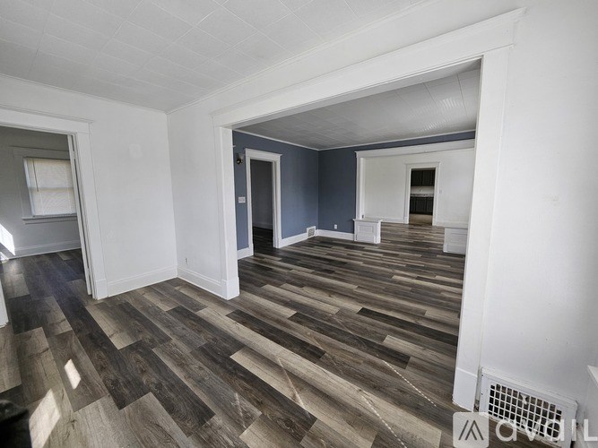 A room with wooden flooring and white walls.
