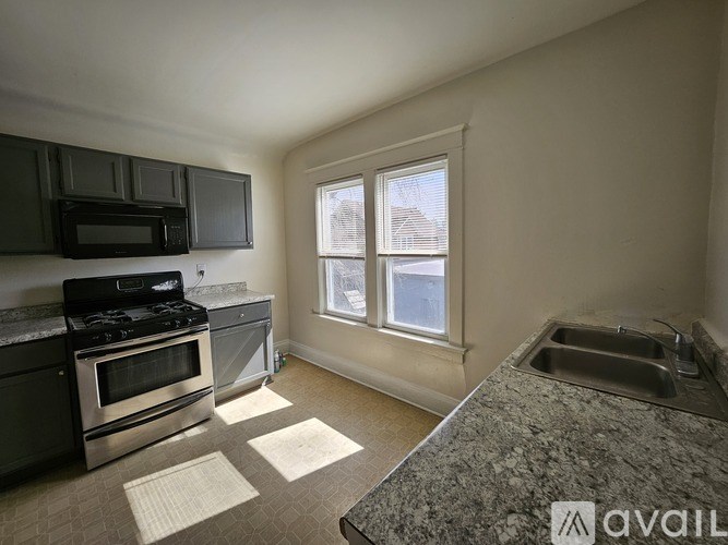 A kitchen with a granite countertop and stainless steel appliances.