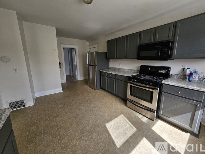 A kitchen with a black microwave above the stove.