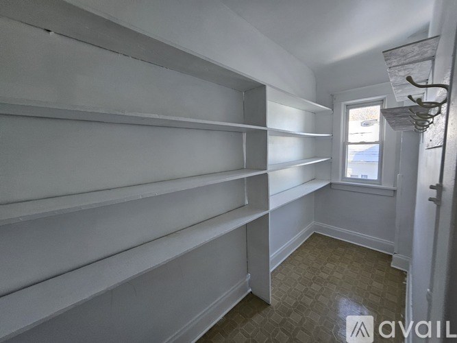 A room with white shelves and a window.
