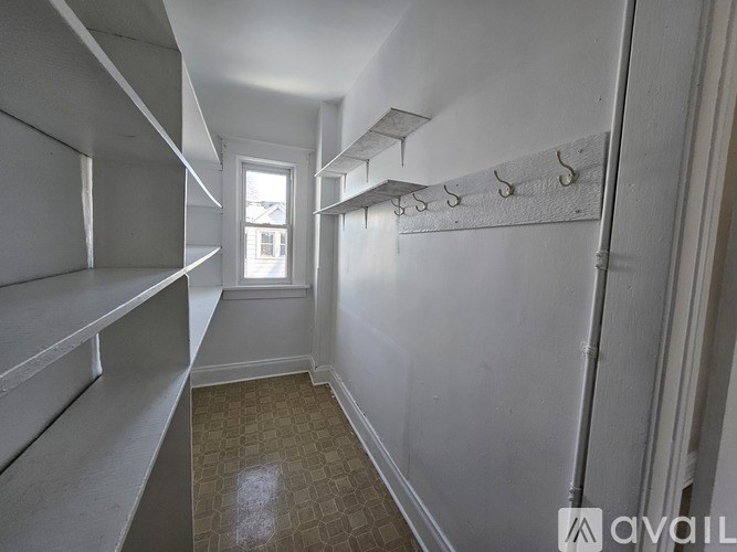 A long hallway with a checkered floor and white walls.