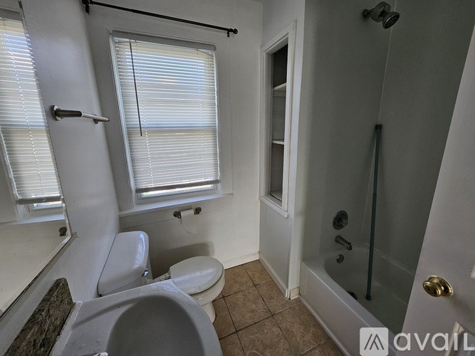 A bathroom with a toilet, sink, and shower.