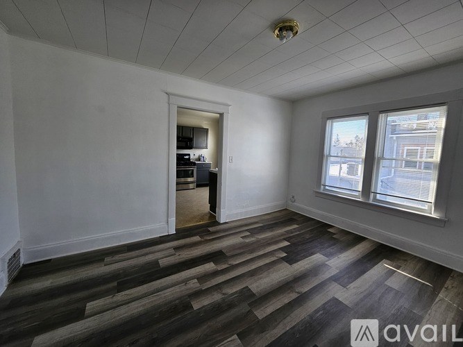 A room with wooden flooring and a window overlooking a street.