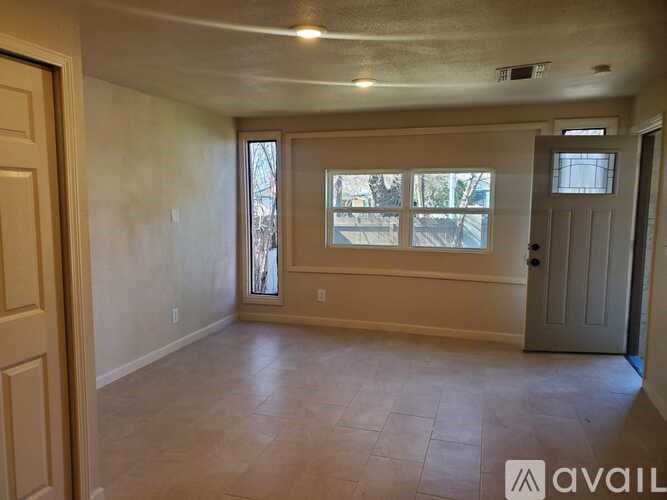 A room with a door, a window, and a tiled floor.