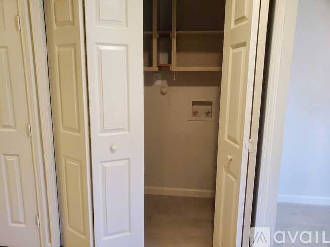 A white door is open to a small kitchen.