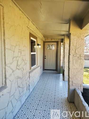 A hallway with a tiled floor and a stone wall.