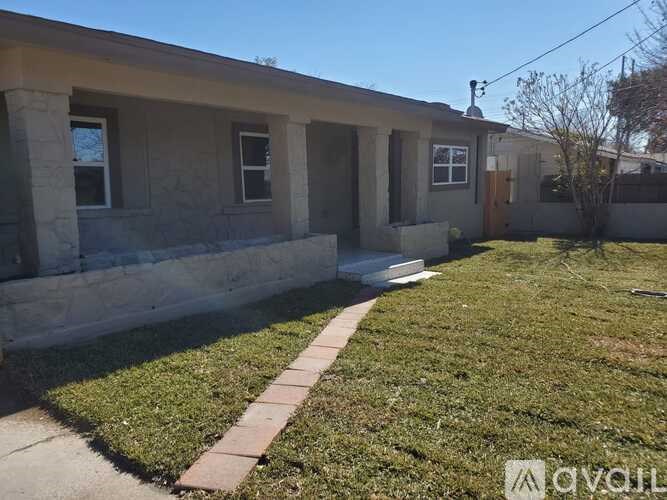 A small house with a brown door and a brown walkway in front.