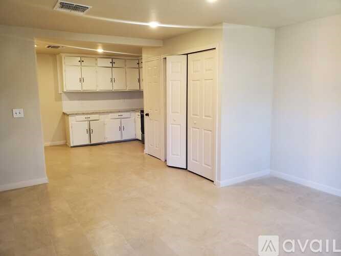A room with a white door and a white cabinet above it.