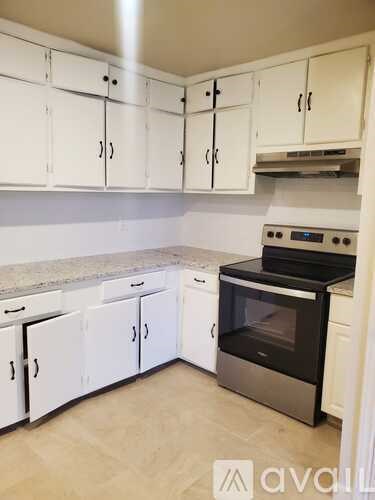 A kitchen with white cabinets and a black oven.