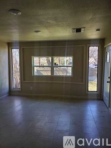 A room with a large window and tiled floor.
