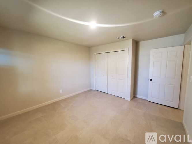 A room with a white door and a white closet with a white ceiling and floor.