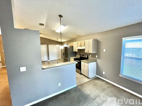 A kitchen area with a counter and cabinets.