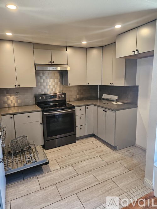 A kitchen with white cabinets and a black stove top oven.