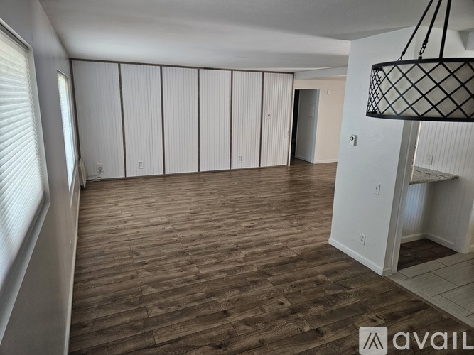 A kitchen area with a wooden floor and a stainless steel counter.