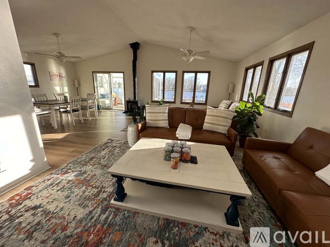 A living room with a white couch and a rug with a pattern of red, blue, and grey.