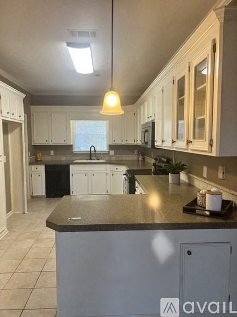 A kitchen with a granite countertop and white cabinets.