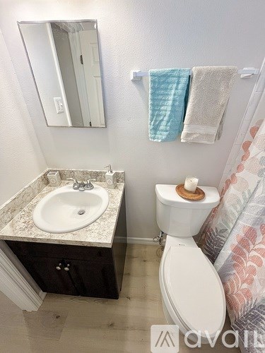 A bathroom with a toilet, sink, and towel rack.