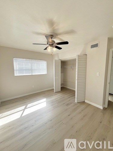 A room with a ceiling fan and sliding doors.