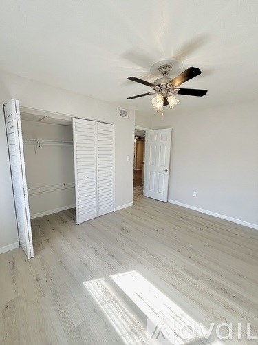 A room with a ceiling fan and a sliding door.
